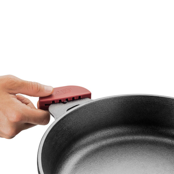 imagem que mostra uma mão colocando o pegador de borracha, que ajuda o cozinheiro a não se queimar