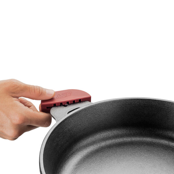 imagem da caçarola de ferro fundido, uma mão demonstra a questão do pegador eficaz que não queima a mão do cozinheiro